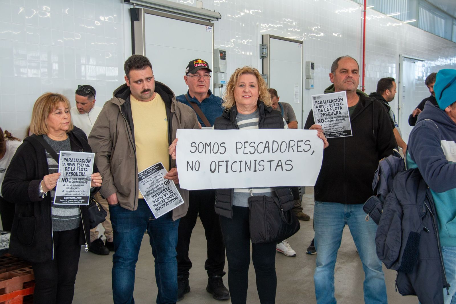 Una mujer porta una pancarta señalando que son pescadores y no oficinistas