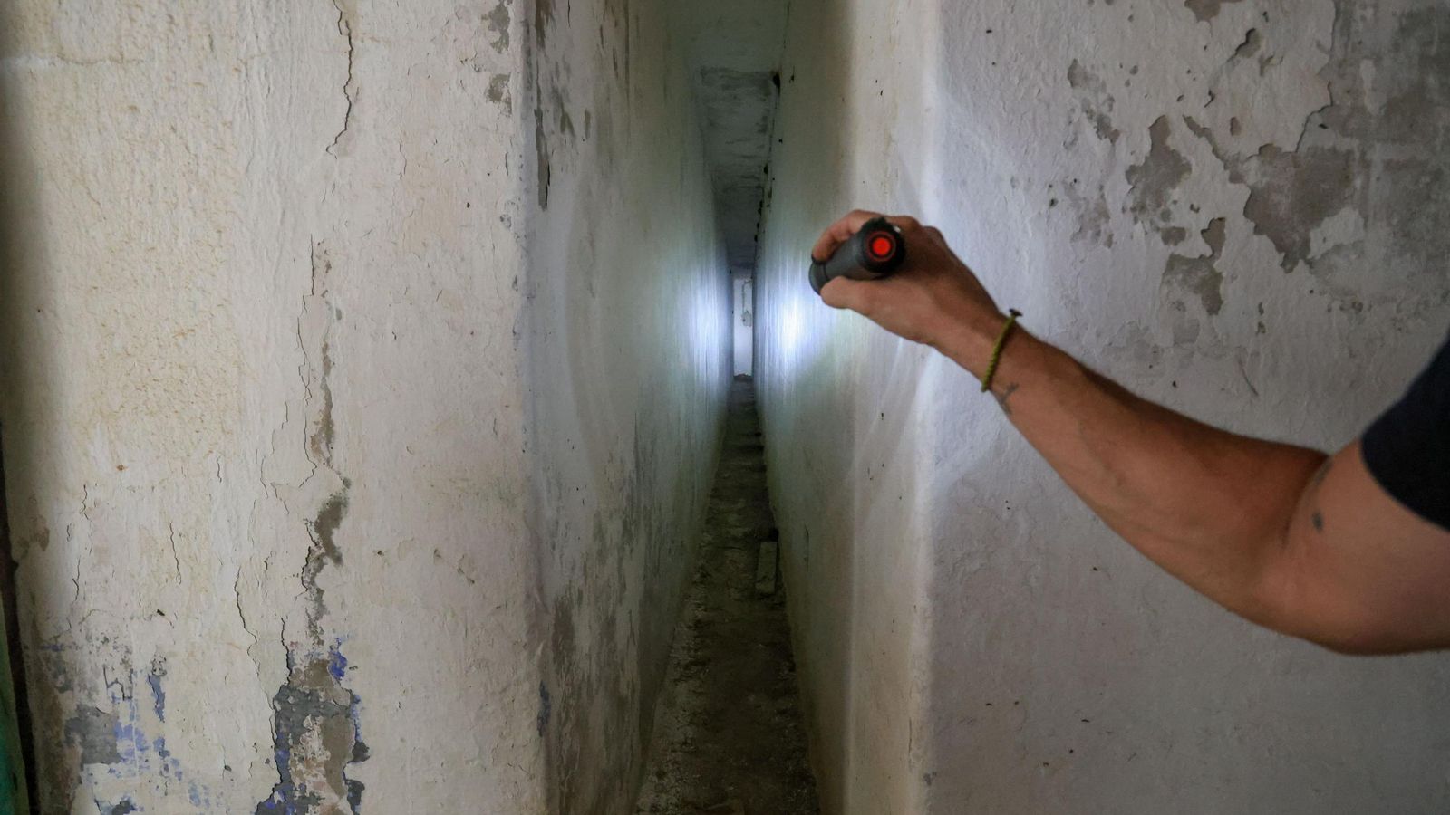 Un largo pasillo interior entre gruesos muros de hormigón, diseñado para absorber la onda expansiva de los cañonazos y resguardar posiblemente a los soldados.