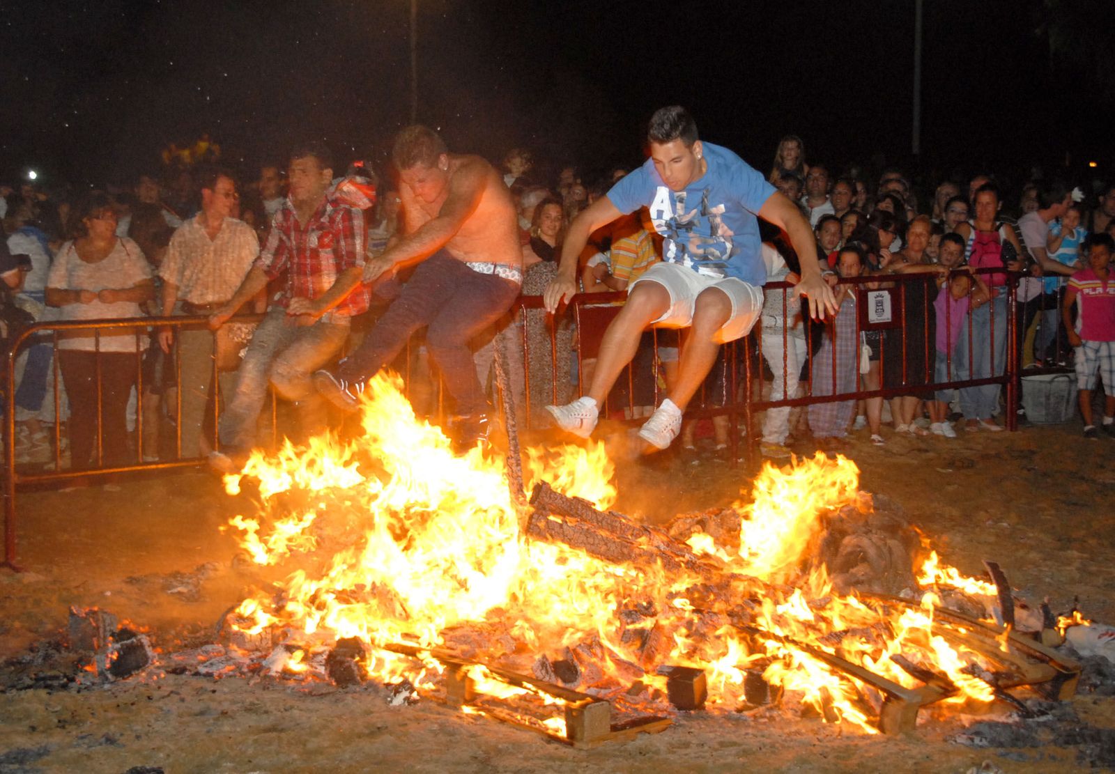 Dos jóvenes saltando una hoguera de San Juan.