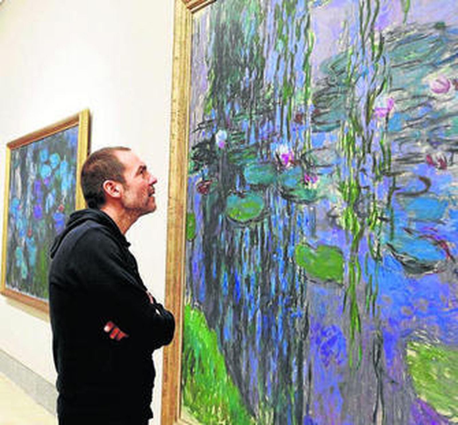 Un hombre observa 'Nenúfares' en la exposición de Monet.
