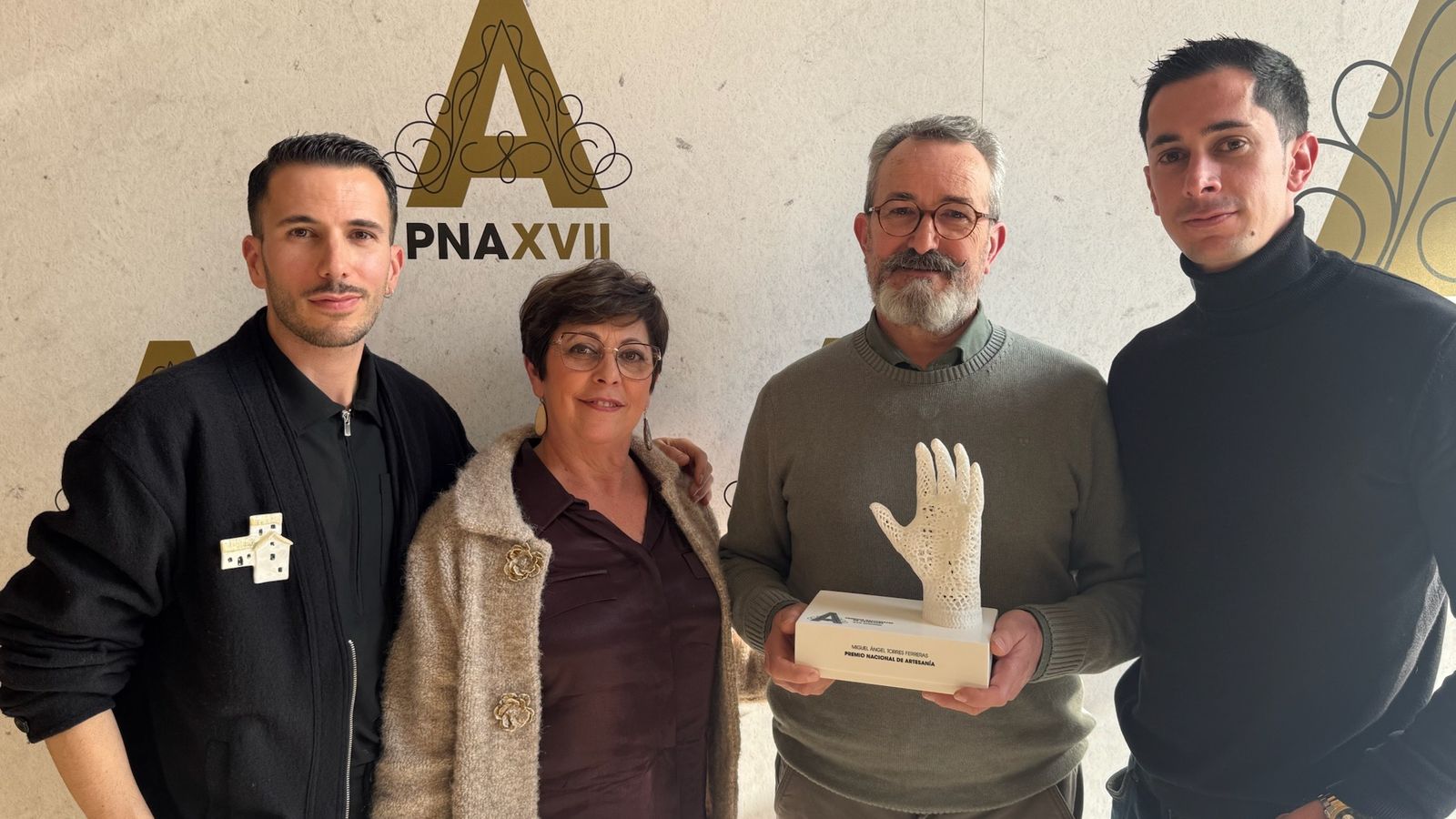 Miguel Ángel Torres Ferreras sostiene el premio nacional junto a su mujer y sus hijos.