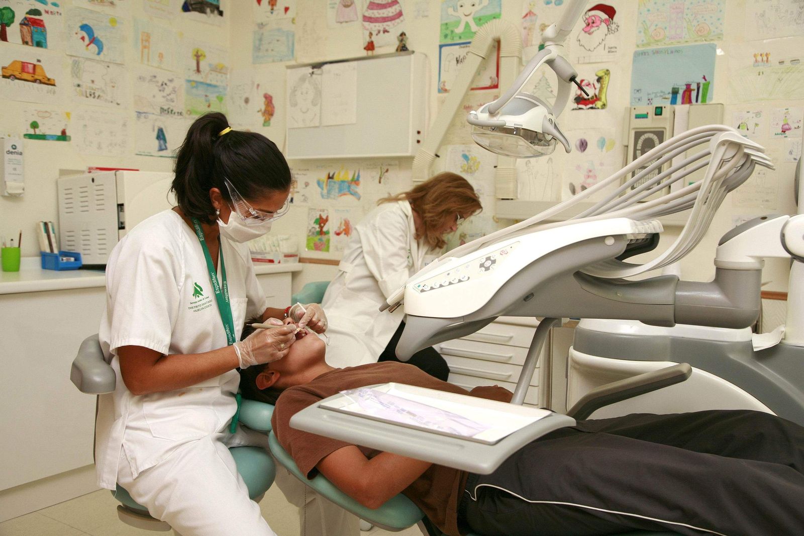 Dentistas atendiendo a varios pacientes en consulta.