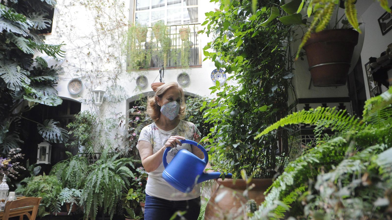 Maribel Navajas riega las plantas de su patio de la calle Parras, 5.