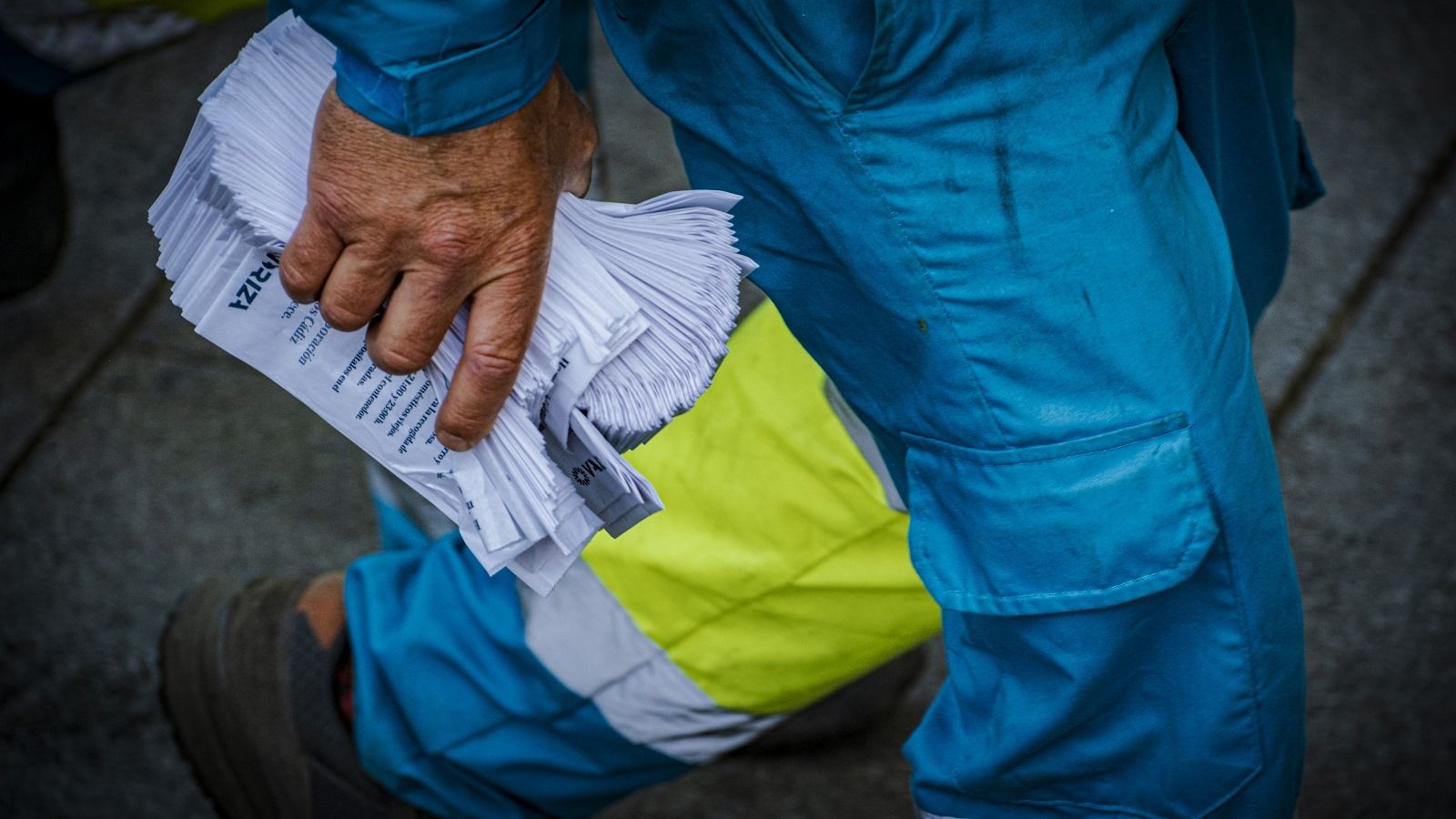 Un empleado del servicio de limpieza, con las bolsas para cáscaras repartidas en la carrera oficial.