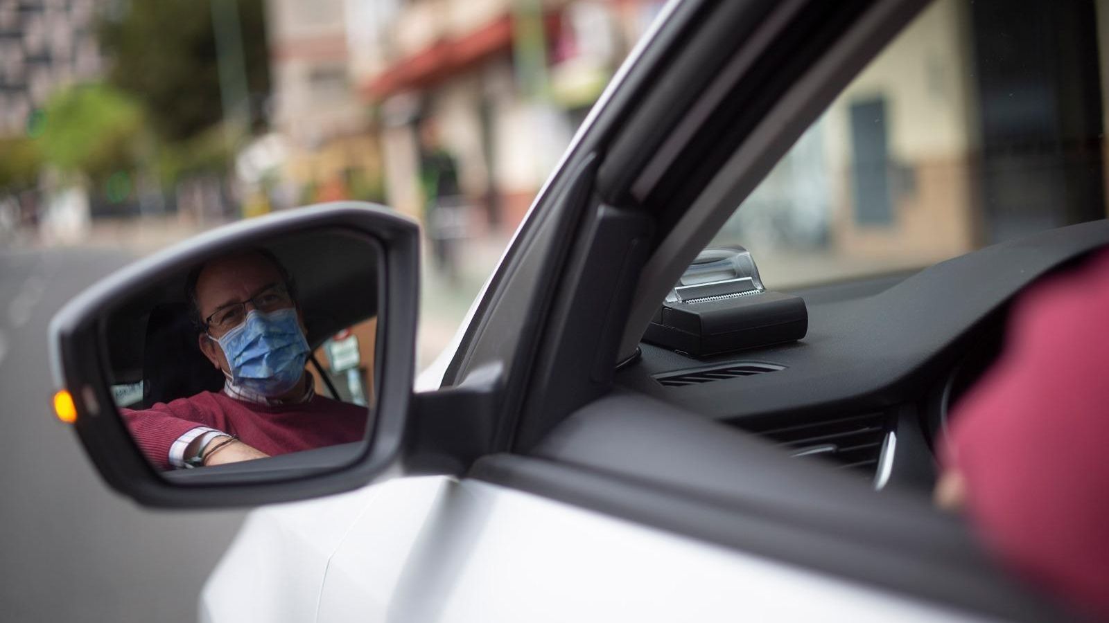 El taxista, reflejado en el espejo retrovisor de su vehículo.