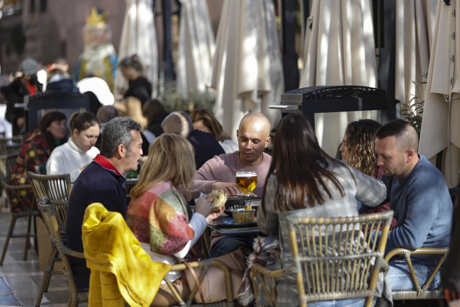 Varias personas comiendo y bebiendo en la terraza de un negocio de hostelería, en una imagen de archivo.