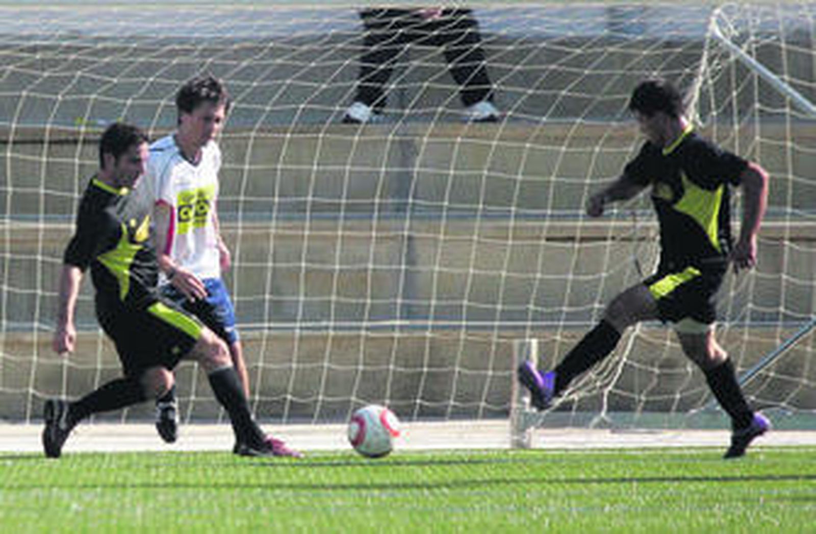 Un jugador del Neumáticos Alcalá frena la internada de un rival.