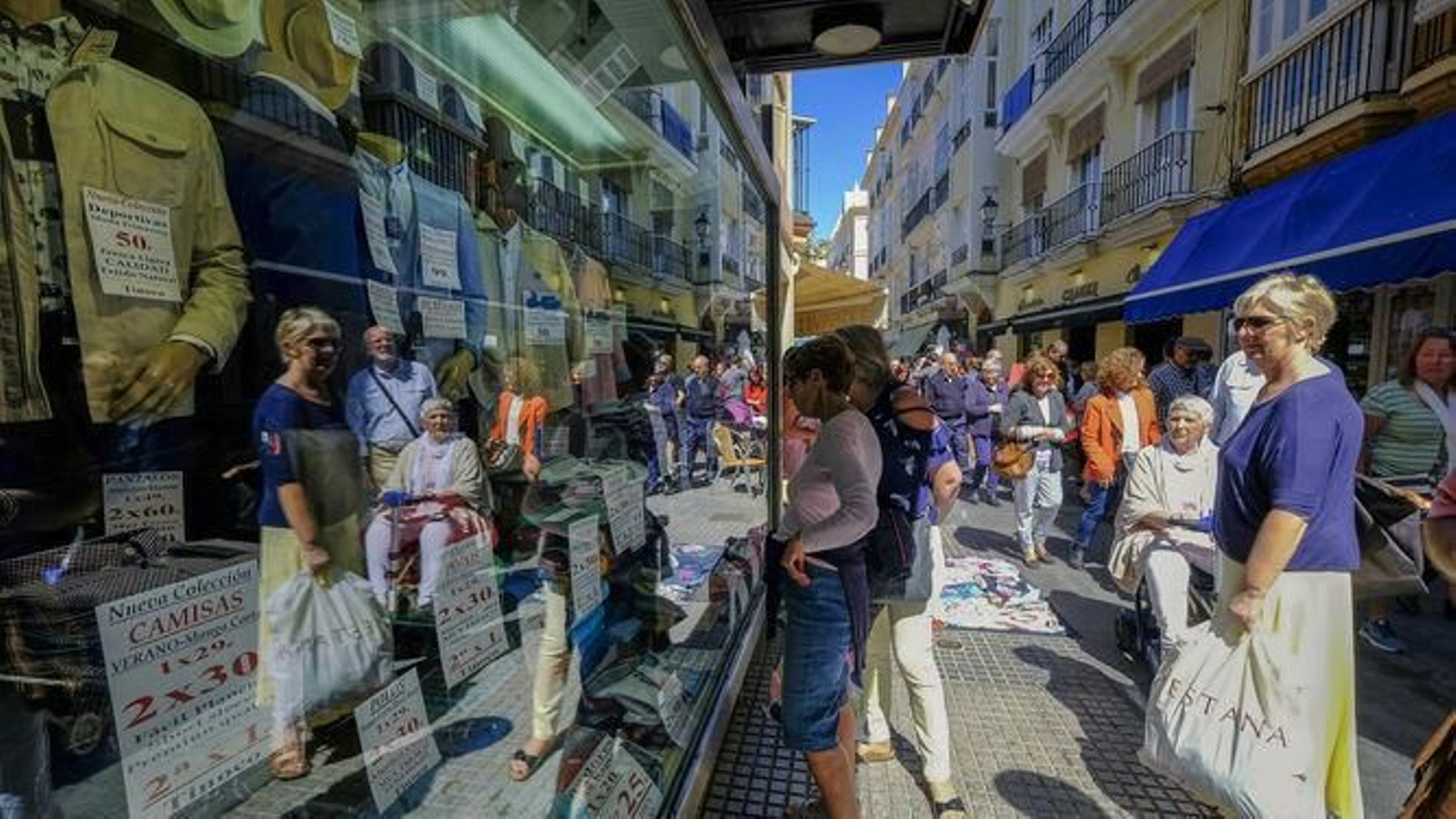Turistas miran el escaparate de una tienda local en Cádiz