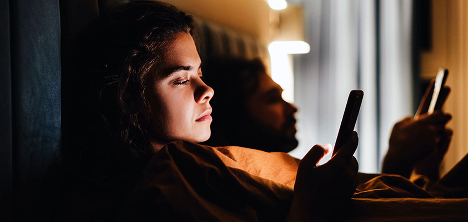 Pareja conectada a Internet desde la cama.
