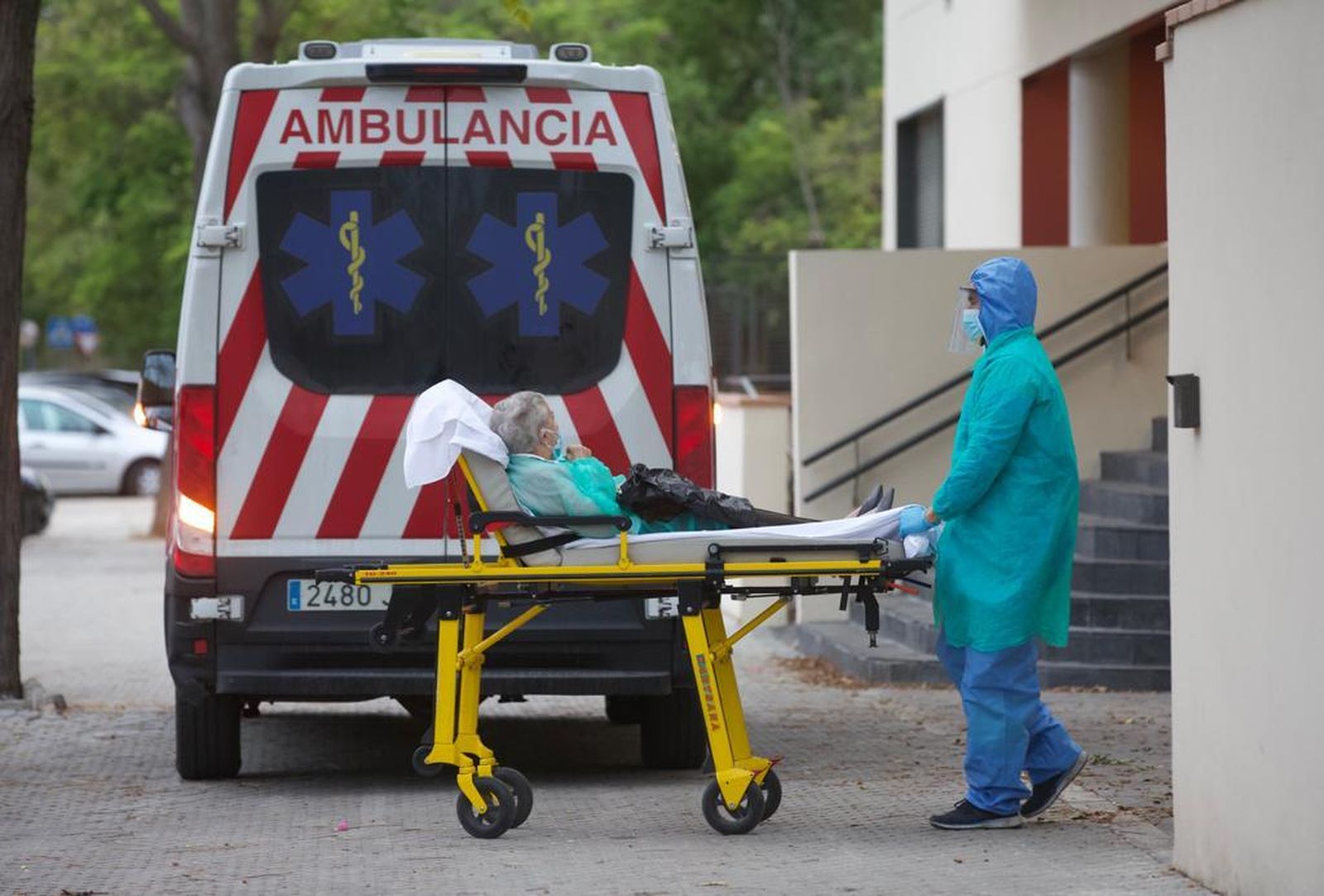 Traslado de una anciana de la residencia Ballesol de Sevilla Este, donde se han confirmado 18 casos y un fallecimiento en las últimas horas.