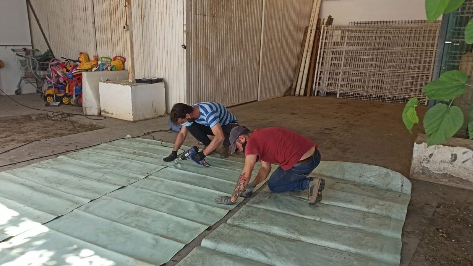 Operarios preparando las lonas de la Expo para instalar una charca.