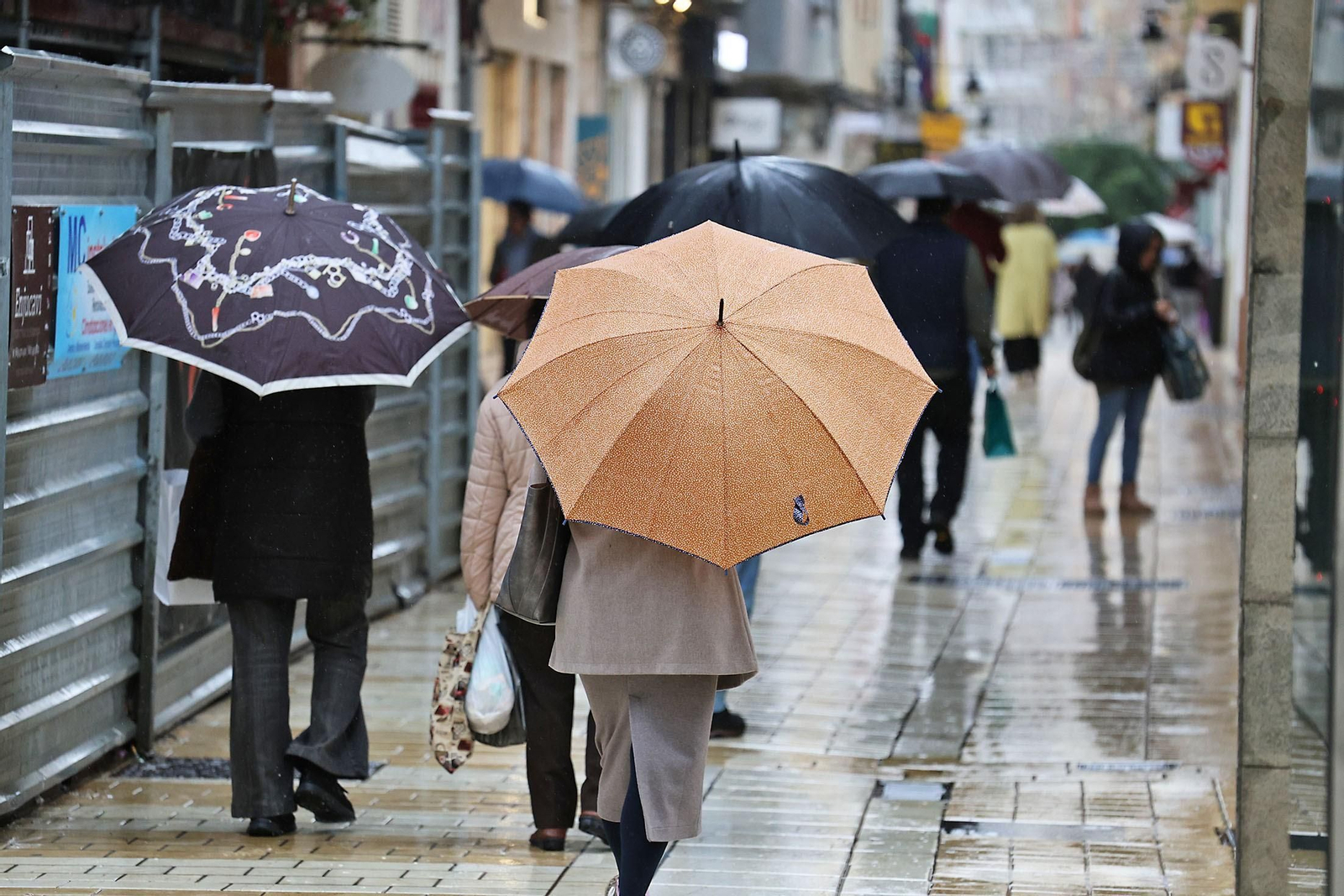 Varias personas con paraguas en el centro de Huelva un día de lluvia.