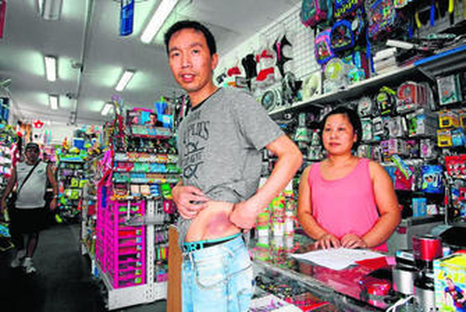 Yun Duo Hu, dueño del comercio muestra junto a su mujer las heridas de la agresión.