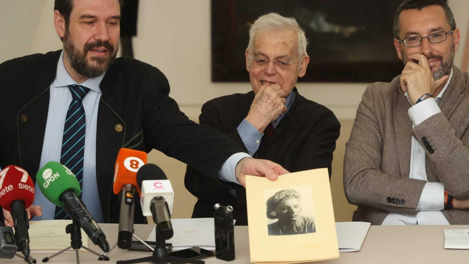 Alfonso Iglesias muestra una fotografía de Madeleine Nonnez-Lopes ante la mirada de su hijo y Juan Franco. Alfonso Iglesias muestra una fotografía de Madeleine Nonnez-Lopes ante la mirada de su hijo y Juan Franco.