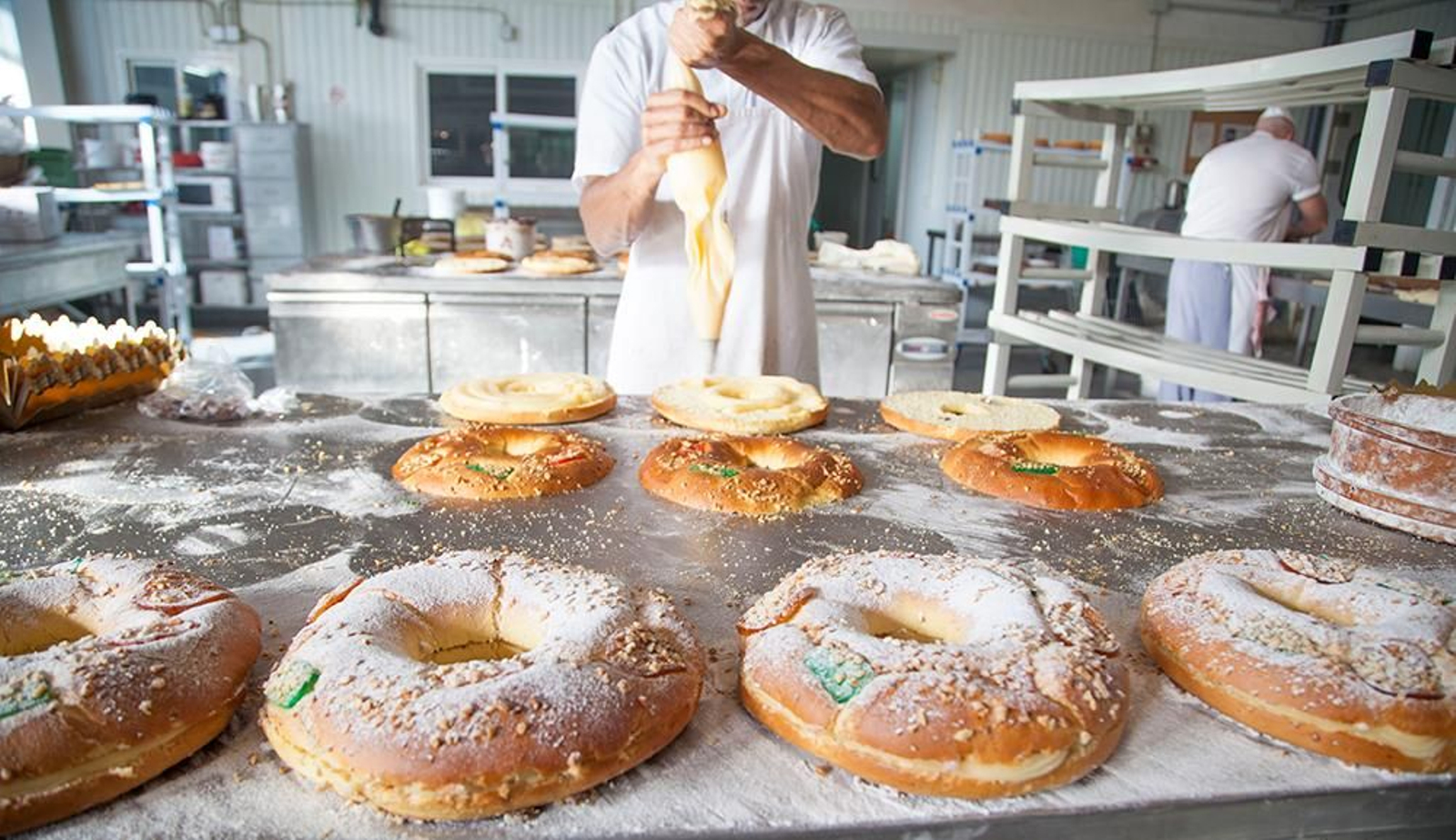 Un cocinero rellena roscones de Reyes en su obrador.