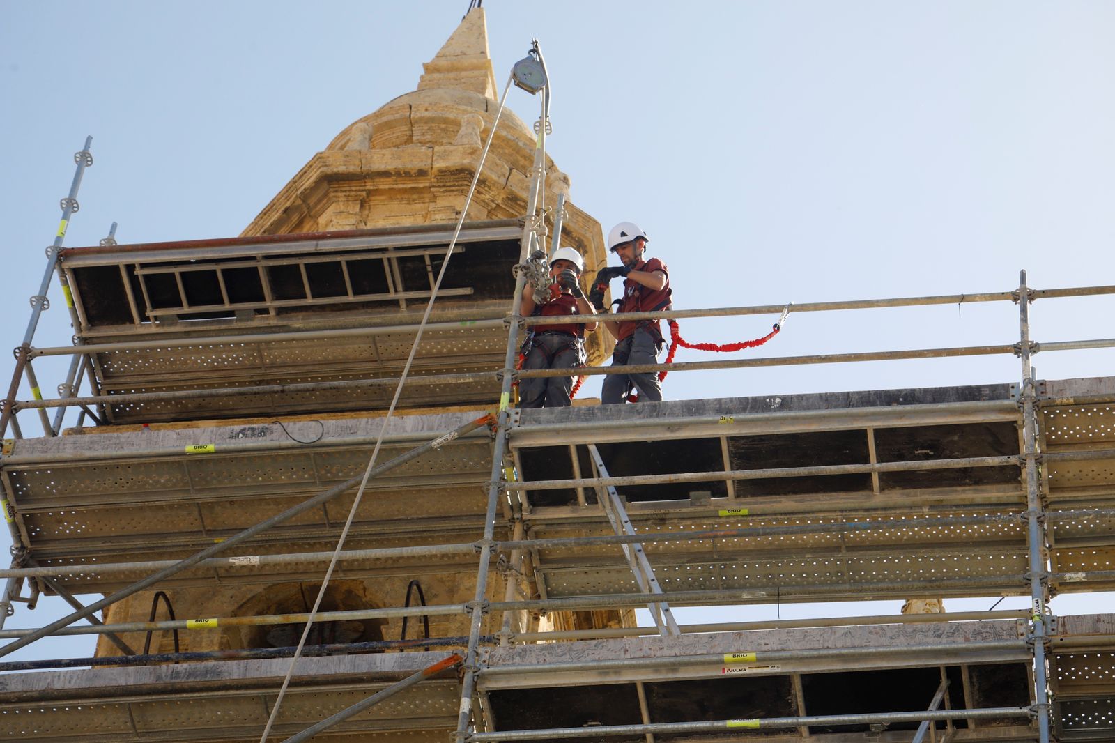 Trabajadores retiran los andamios de la iglesia del Juramento de San Rafael de Córdoba.