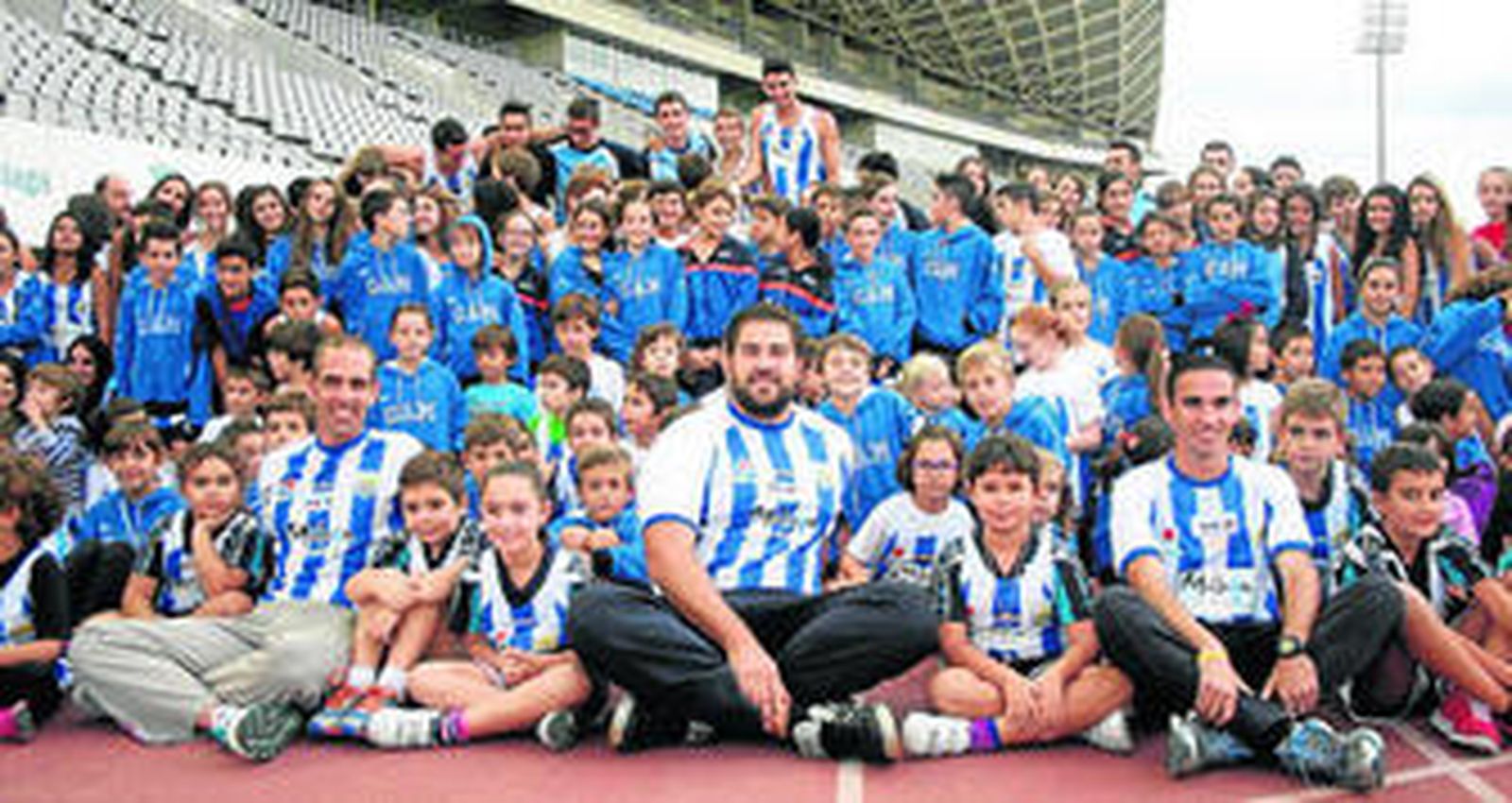 Óscar González, Borja Vivas y Dani Pérez posan con los niños en el Ciudad de Málaga.