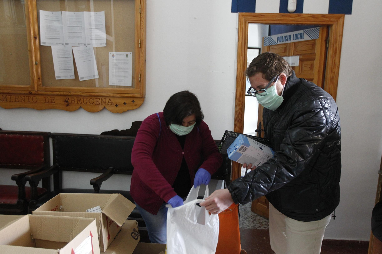 Ismael Gil ayuda a una voluntaria a cargar bolsas de guantes, mascarillas y geles.