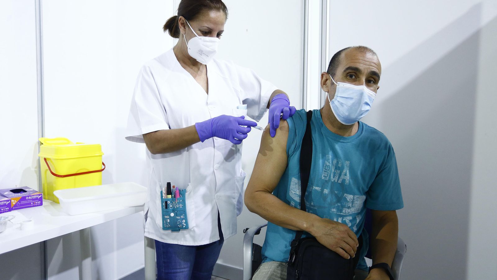 Una enfermera vacuna a un docente.