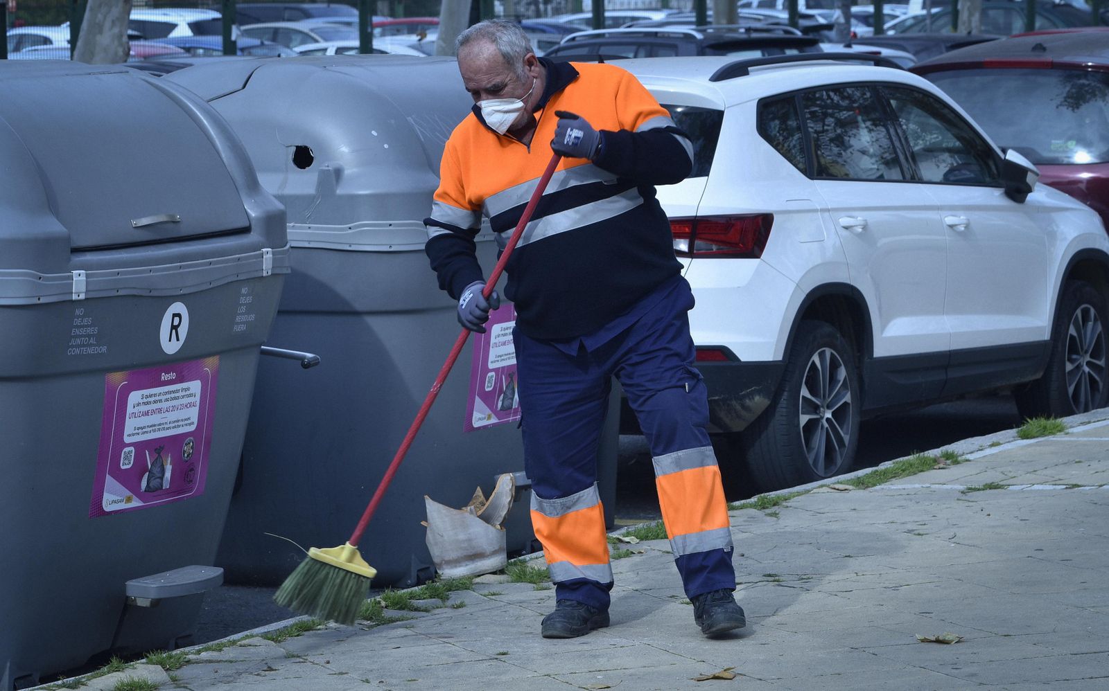 Un operario de la empresa de limpieza barre una acera de la ciudad.
