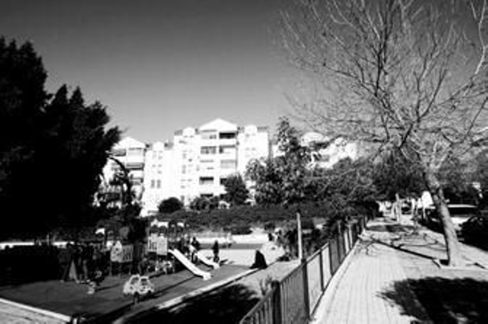 Varios vecinos disfrutan con sus hijos del nuevo parque infantil.