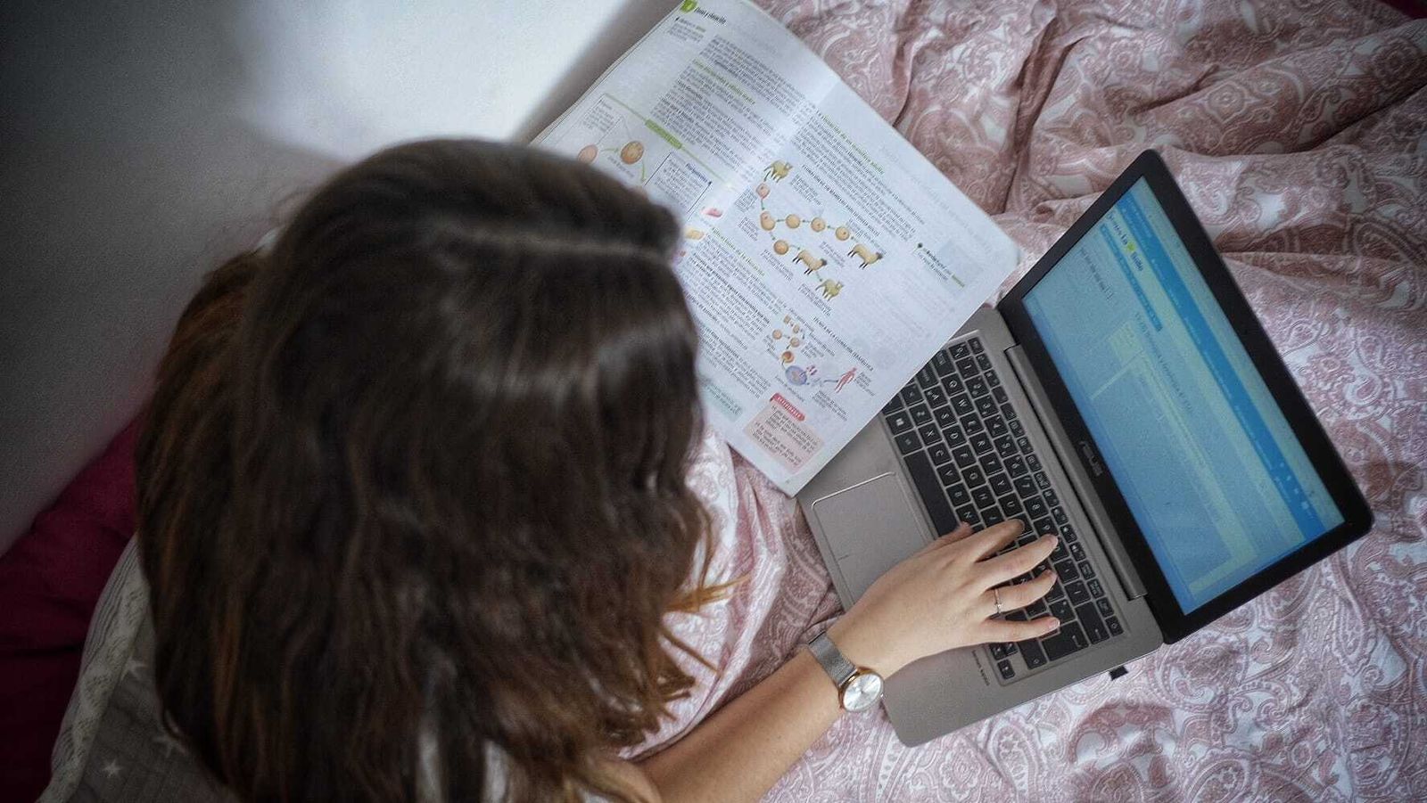 Una estudiante haciendo los deberes en su casa desde el ordenador.