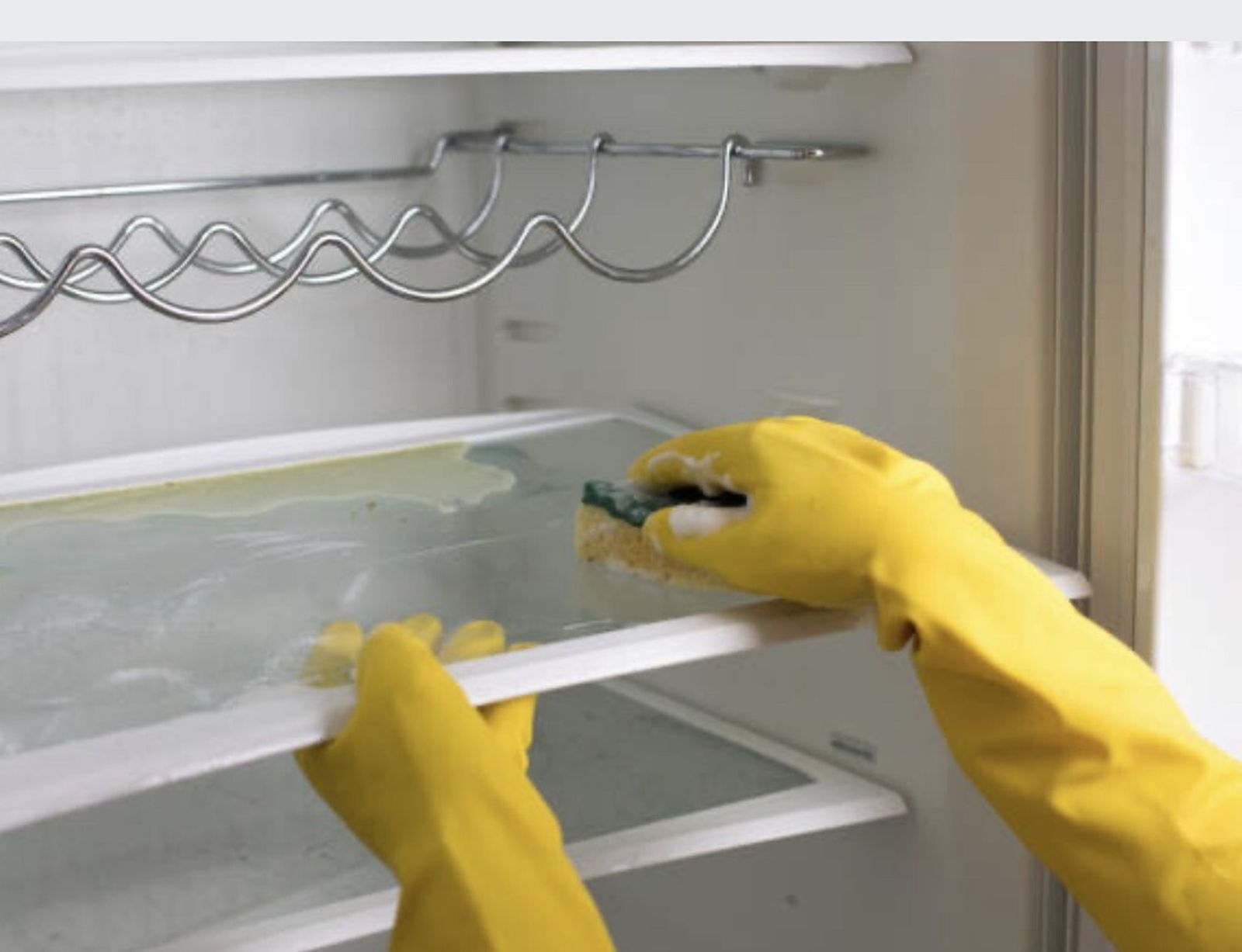 Una persona limpia el frigorífico por dentro