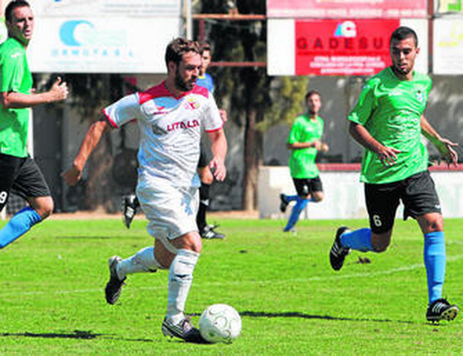 Nico conduce el balón seguido de cerca por el centrocampista del Villamartín Kilian.