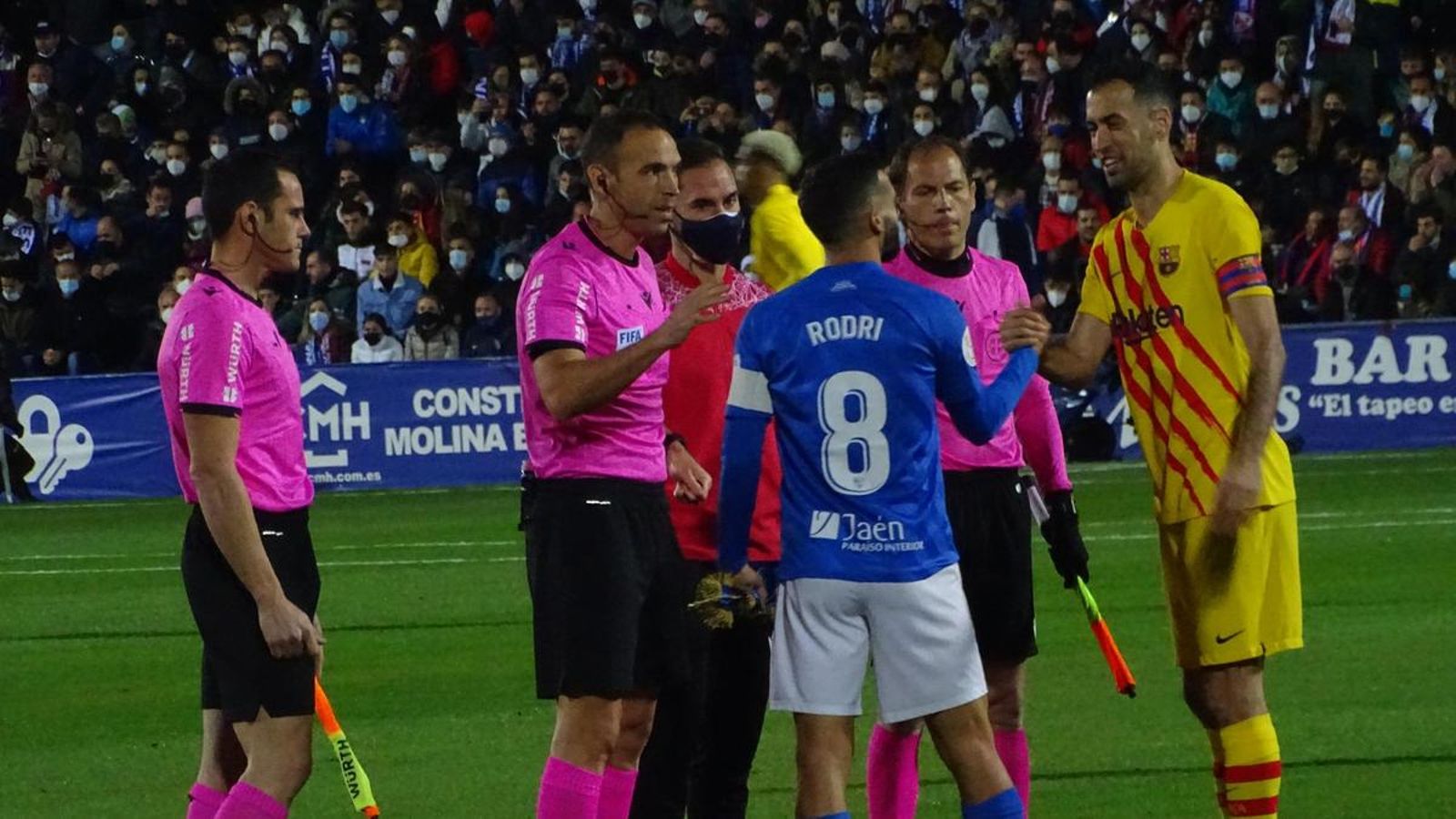Rodri, capitán linarense, saluda a Sergio Busquets, capitán del FC Barcelona, en la eliminatoria que enfrentó a ambos clubes en Linarejos el 5 de enero de 2022.