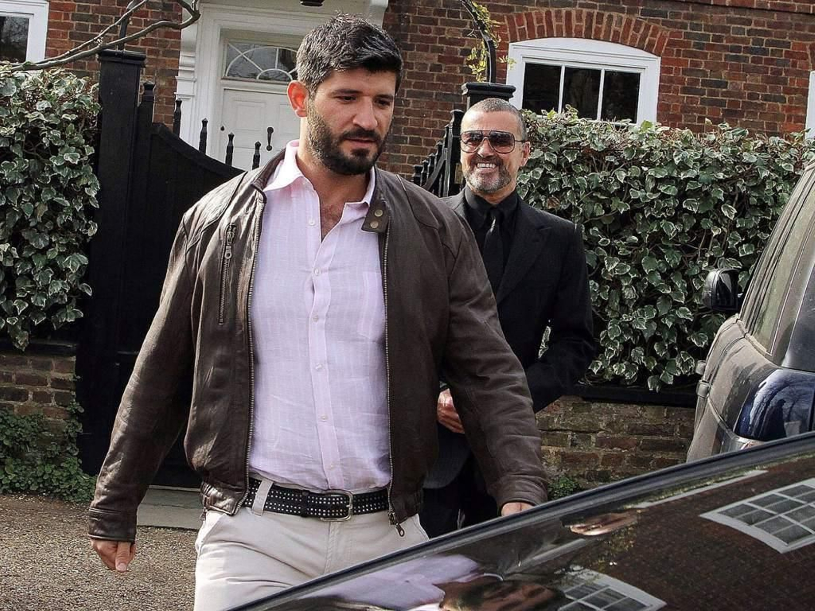 Fadi Fawax (en primer término), escoltando a su pareja, George Michael, a la salida de su casa.