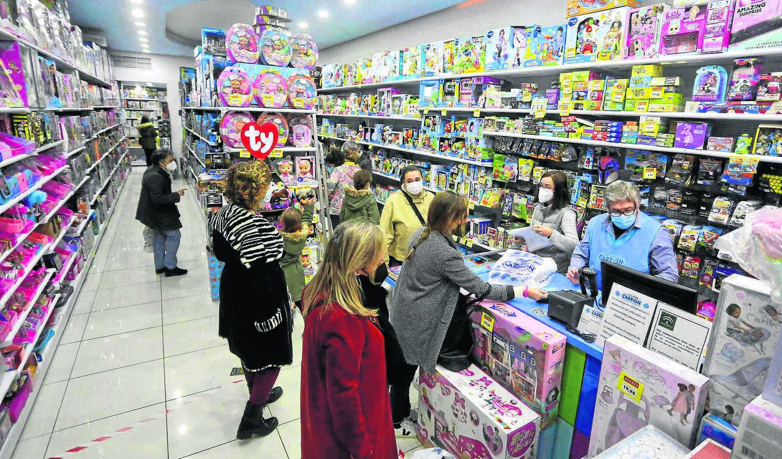 Varios clientes pasan por caja en la juguetería Carrión de calle Nueva.