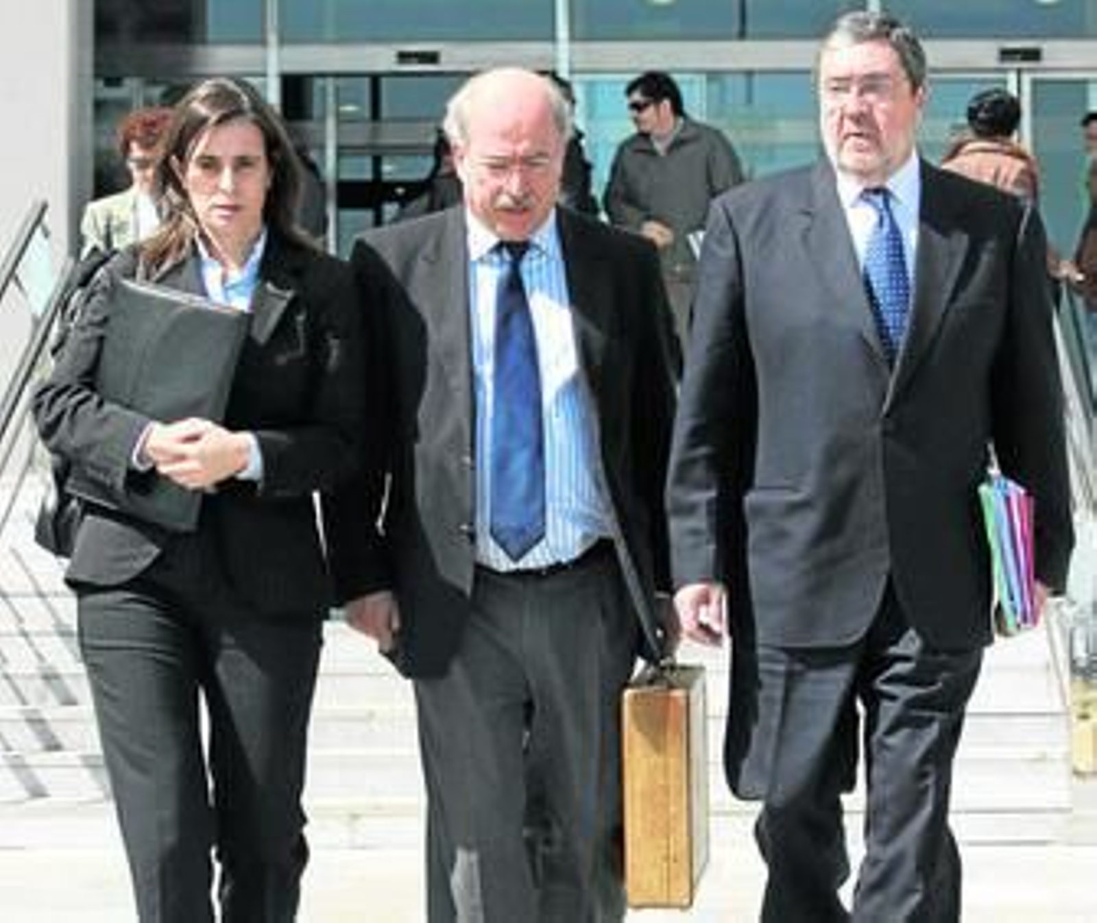 El letrado Fernando del Valle flanqueado por sus abogados al término de una sesión judicial.