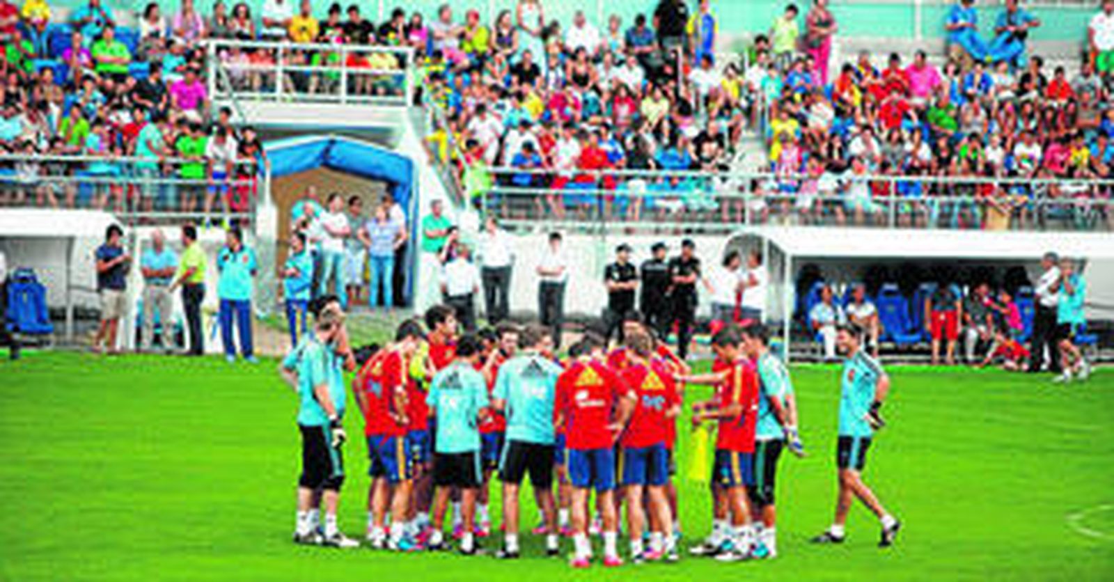 Jugadores y técnicos de España, ayer en el césped del estadio Carranza con la parte baja de la nueva Tribuna poblada de seguidores.
