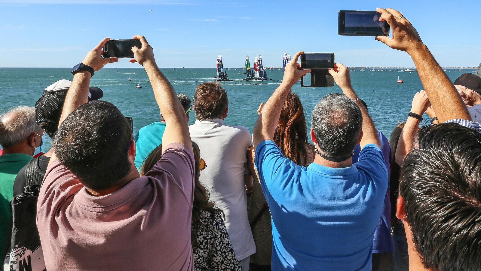 Numerosas personas tratan de inmortalizar una de las salidas de los barcos de SailGP.