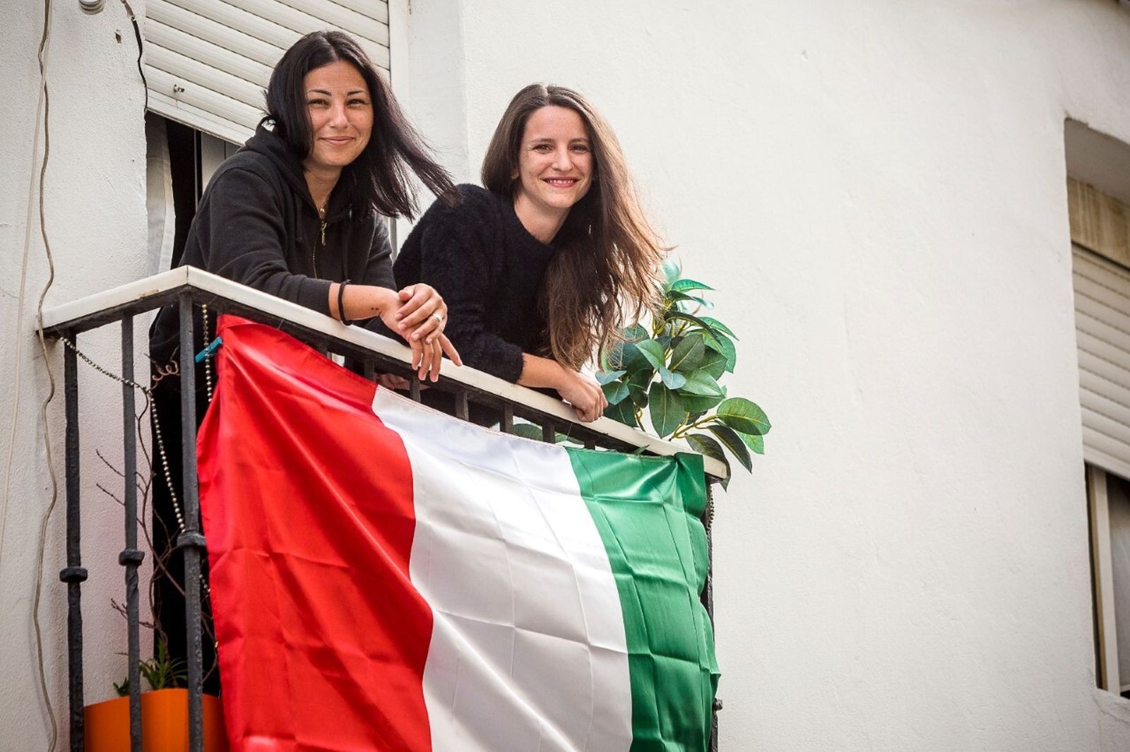 Giulia y Anna, en su balcón de la calle La Rosa engalanado con la bandera de Italia