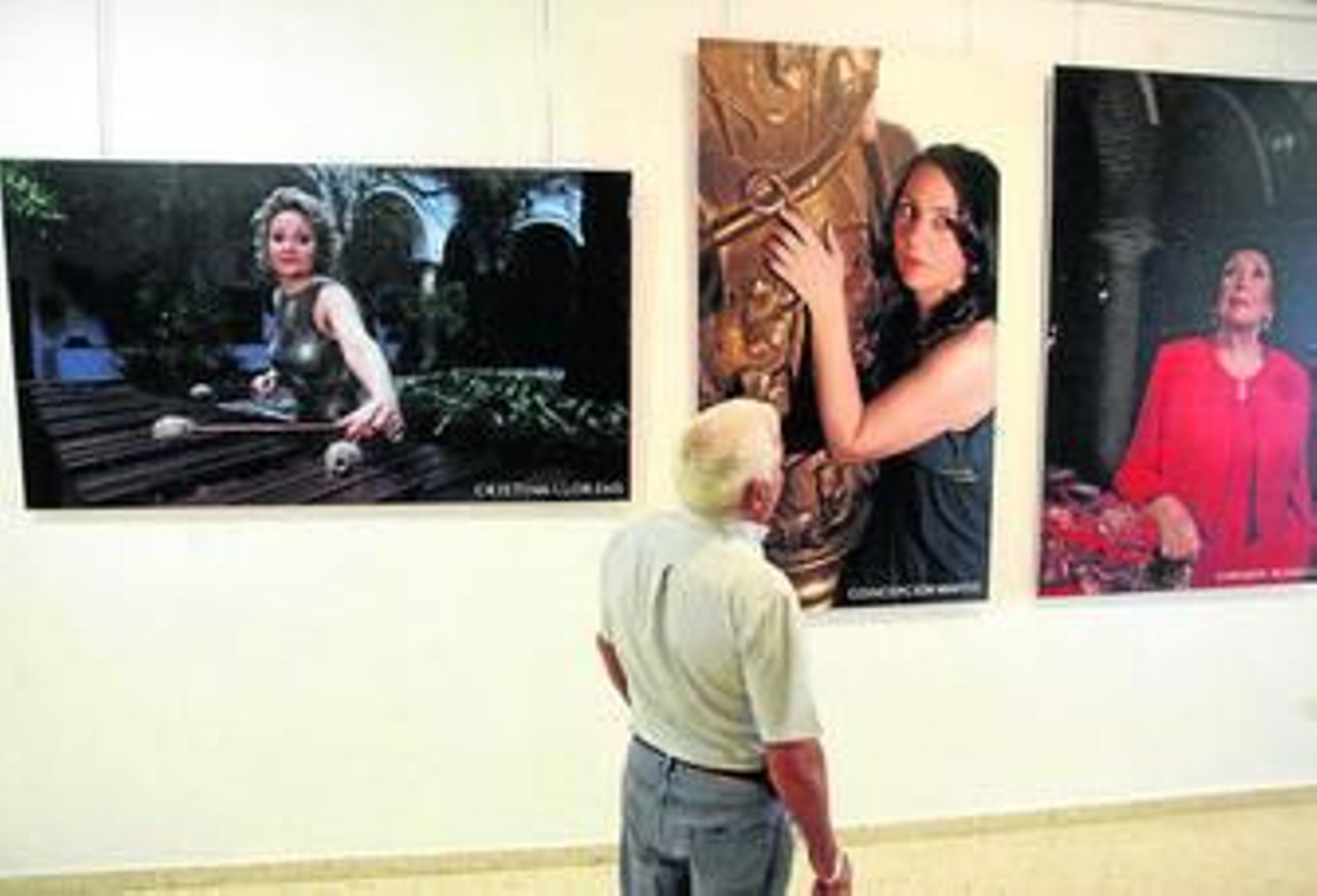 Un hombre contempla tres de las obras de la exposición 'Mujeres músicas'.