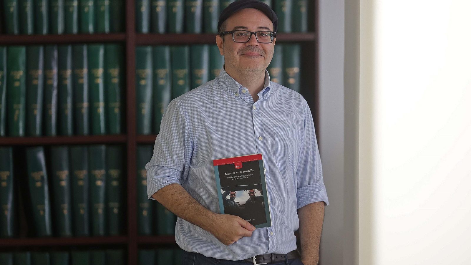 El autor de Sicarios en la pantalla posa con su libro