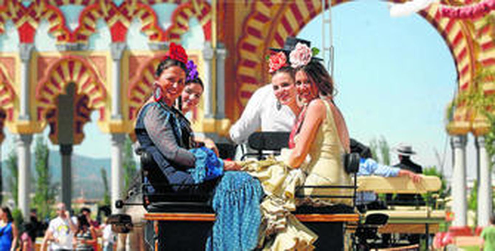 Cuatro mujeres disfrutan de un paseo en carruaje por El Arenal vestidas con sus trajes de gitana.