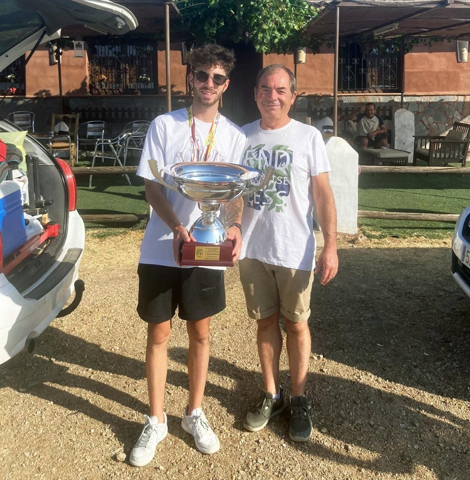Pablo Montes posa con el trofeo de campeón junto a su padre.