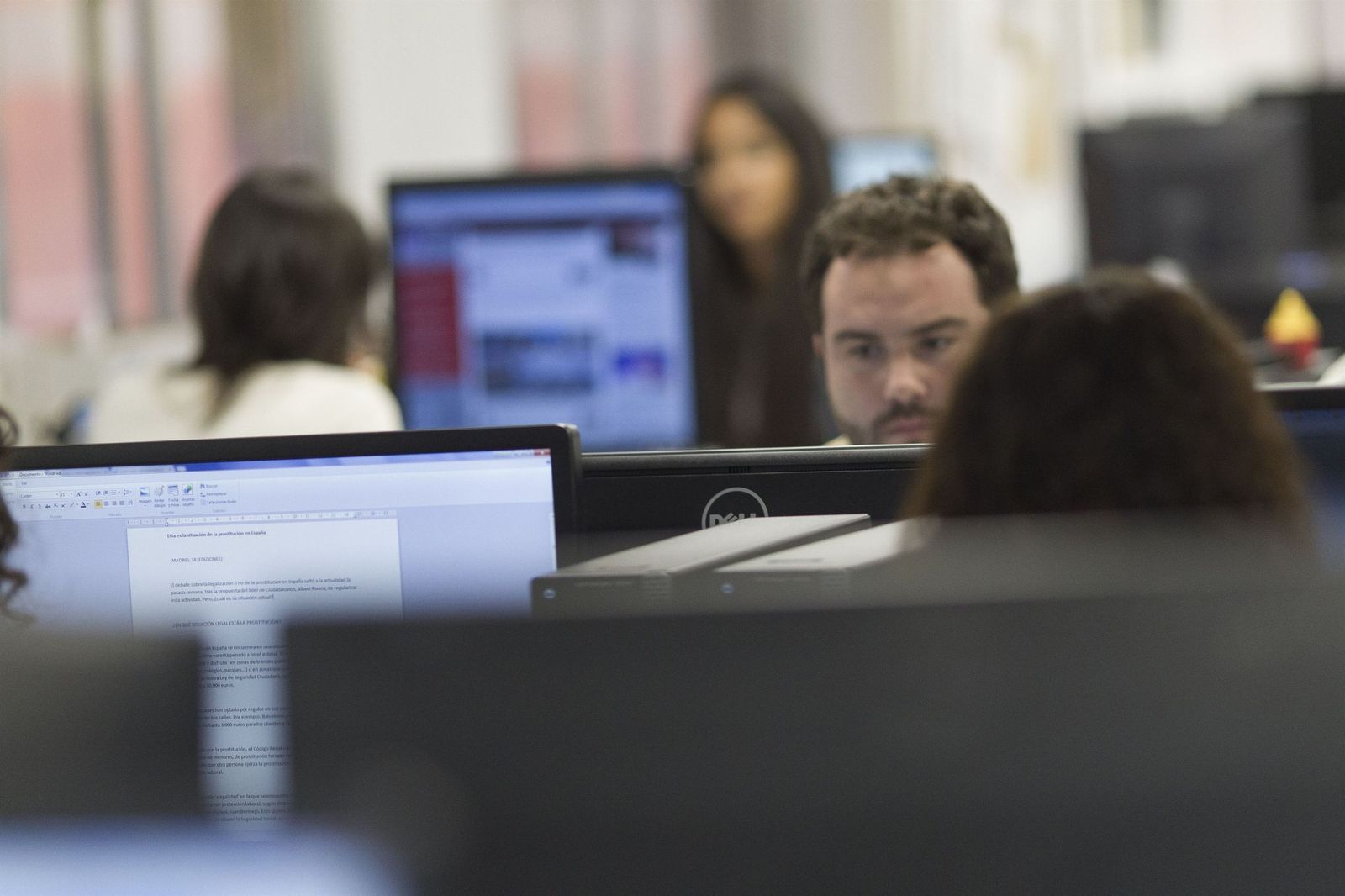 Varias personas trabajan en una oficina.