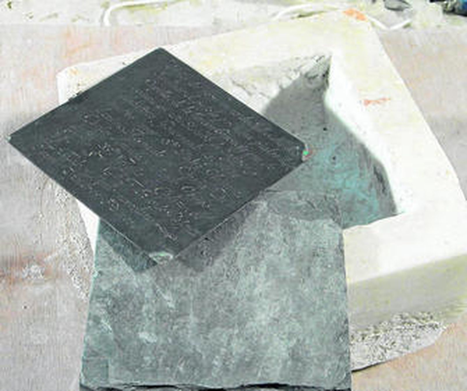 Imagen de la primera piedra del Retablo de los Genoveses (en mármol) con su tapa de pizarra y la placa de cobre.