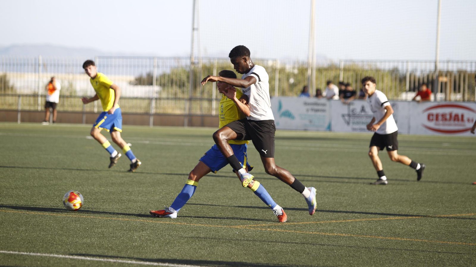 Un jugador cañaero trata de robarle el balón a un rival cadista durante una acción del encuentro.