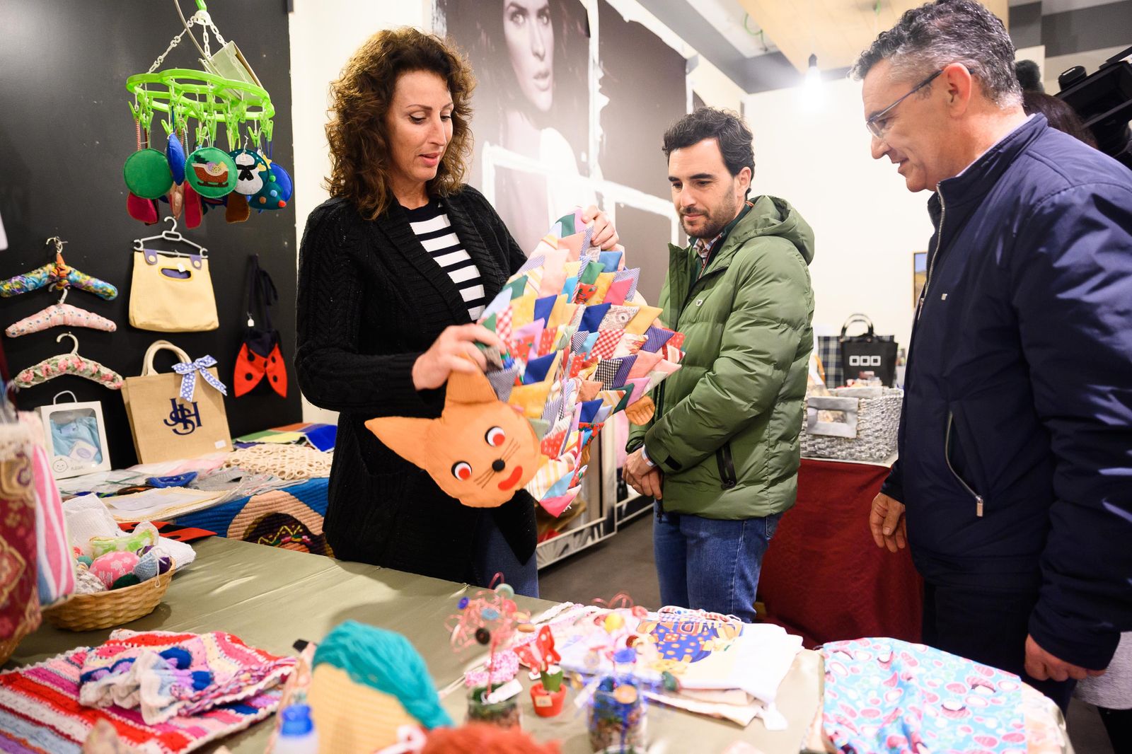 La alcaldesa contempla un cojín de tele hecho a mano