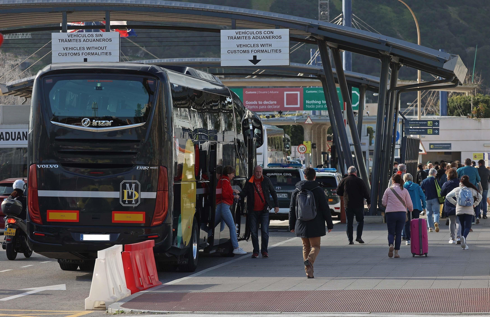 Un autobús de servicio discrecional deja a turistas en el carril de entrada a Gibraltar.