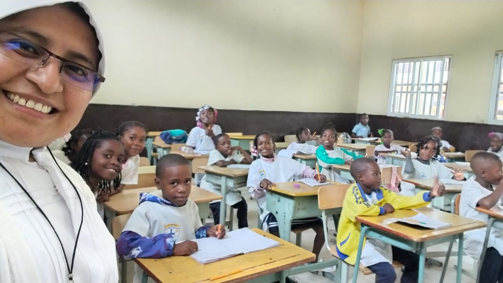 La hermana Justina en la escuela construida gracias a Manos Unidas y los niños y niñas alumnos que reciben clase.