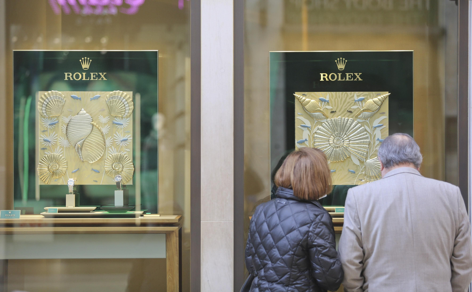 Clientes observan el escaparate de una joyería en calle Larios.