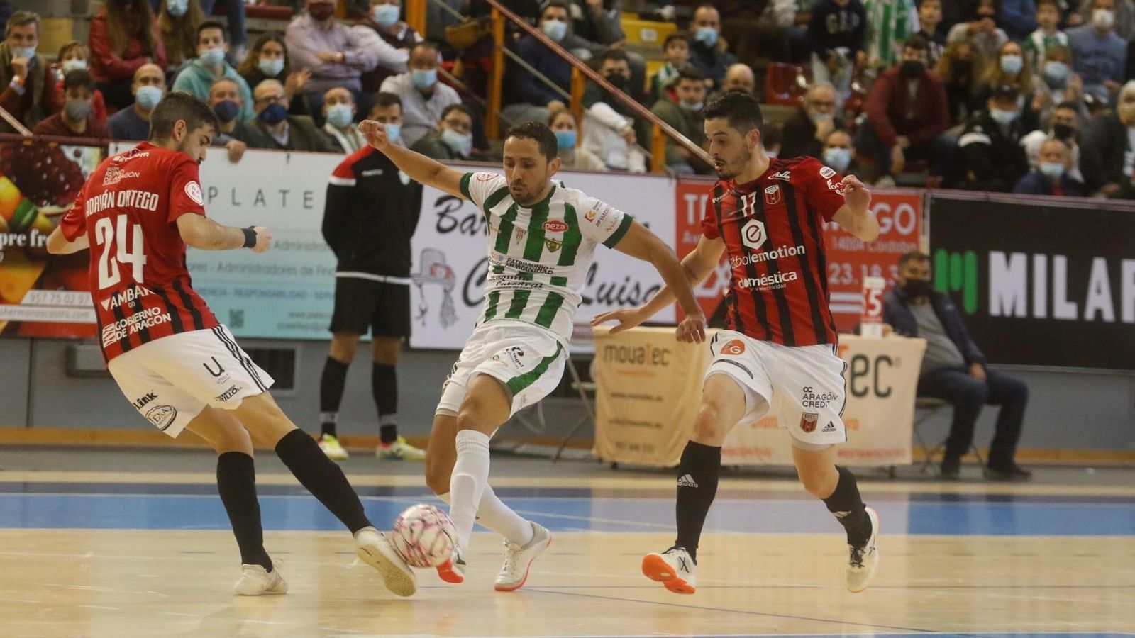 Caio intenta colarse entre dos jugadores del Fútbol Emotion Zaragoza.