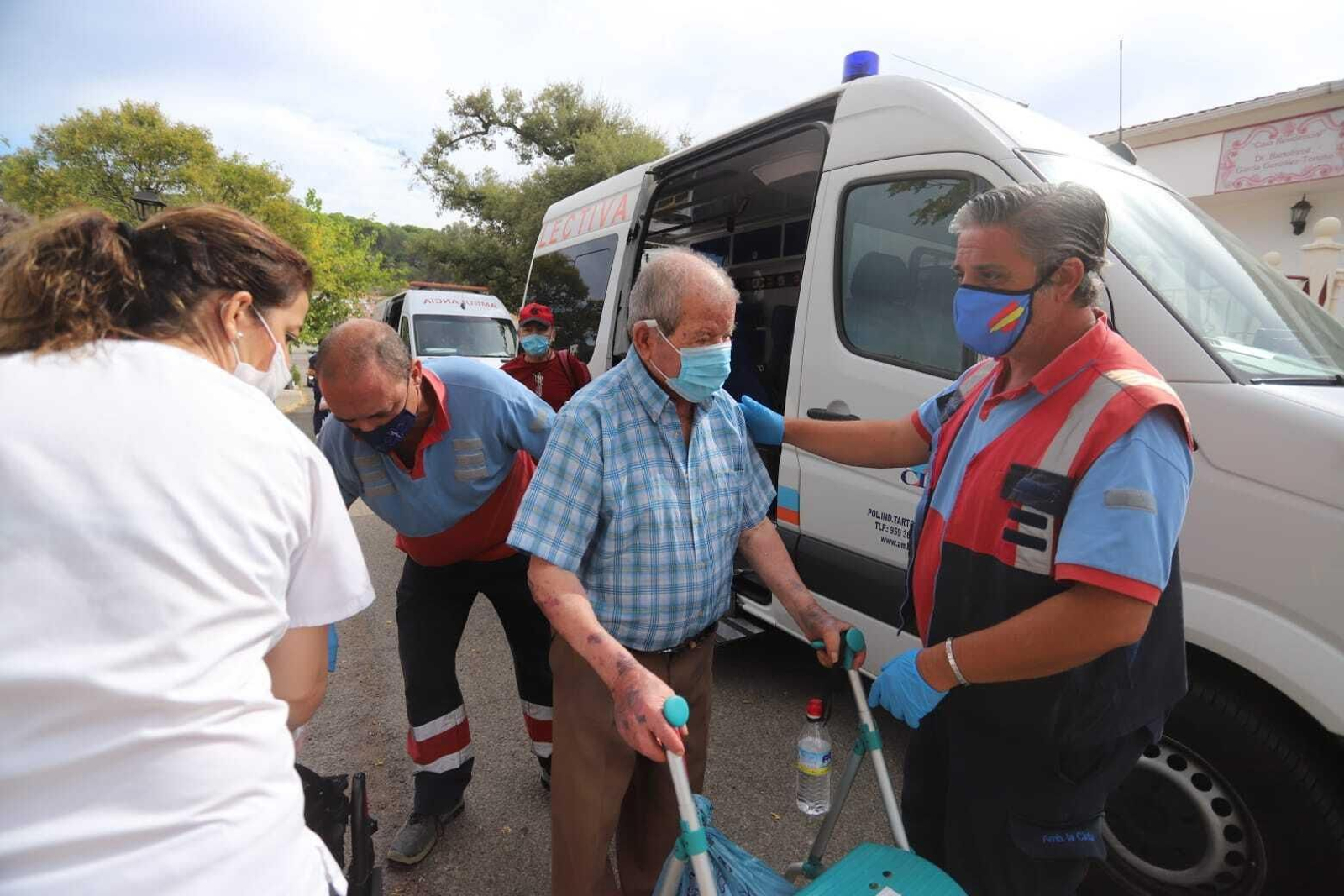 Los mayores, acompañados por los técnicos, descienden de la ambulancia.