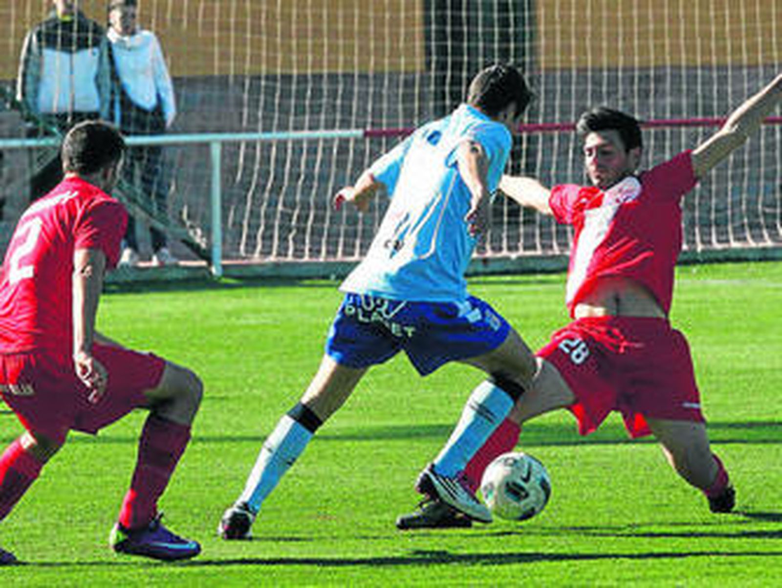 Un jugador del Baza trata de eludir la entrada de un defensa del Atlético La Zubia.