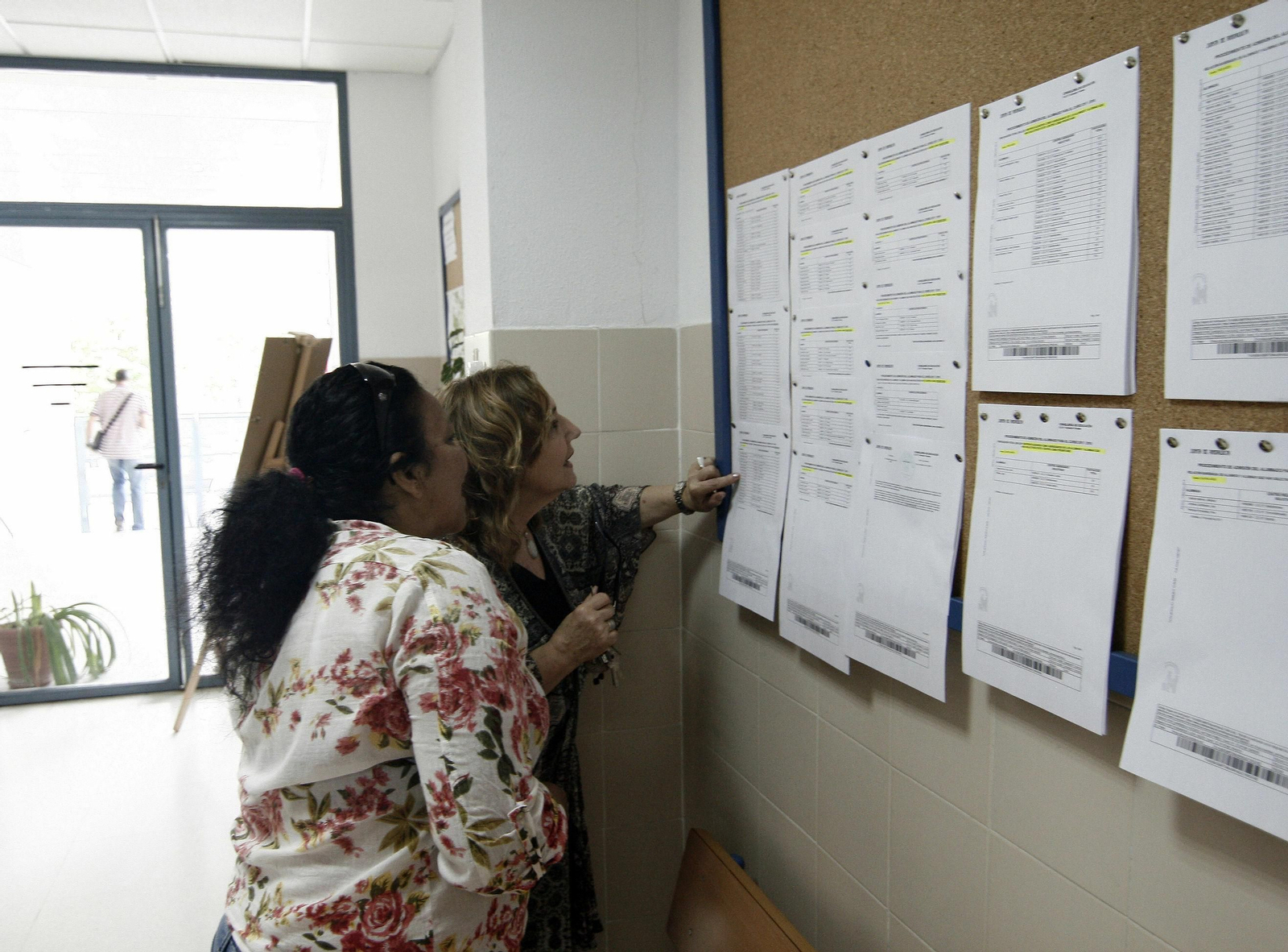 Imagen de archivo de familias consultando las listas de escolarización.